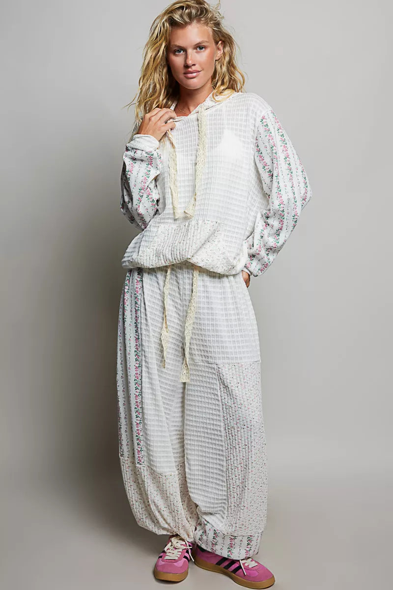 Ivory patchwork knit wide-leg pants with gathered elastic waistband and tassel tie accents