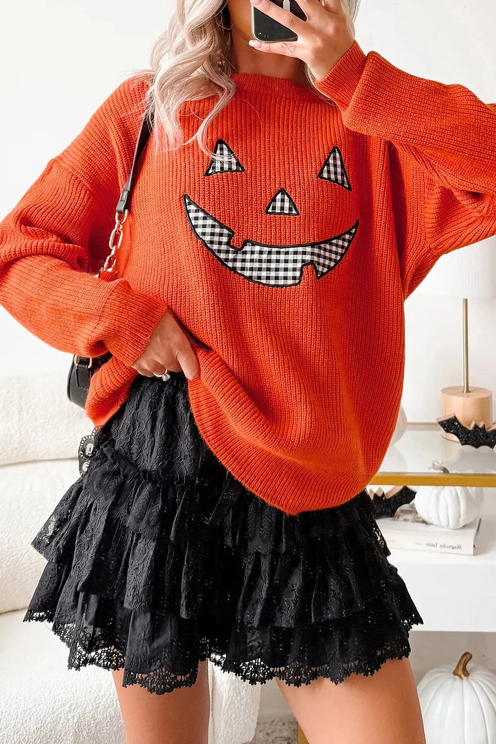 Orange knit sweater with jack-o-lantern graphic, long sleeves, round neck