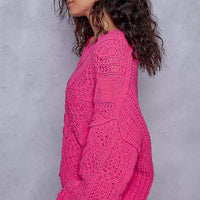 Fuchsia cable-knit cropped V-neck sweater shown from side, textured knit and ribbed cuffs