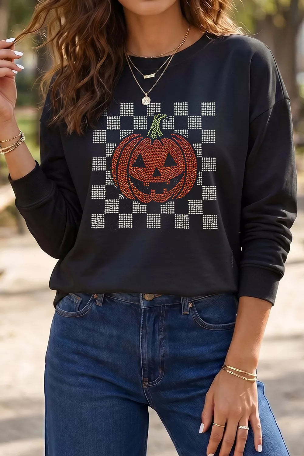 Black long sleeve sweatshirt with rhinestone checkerboard pumpkin graphic