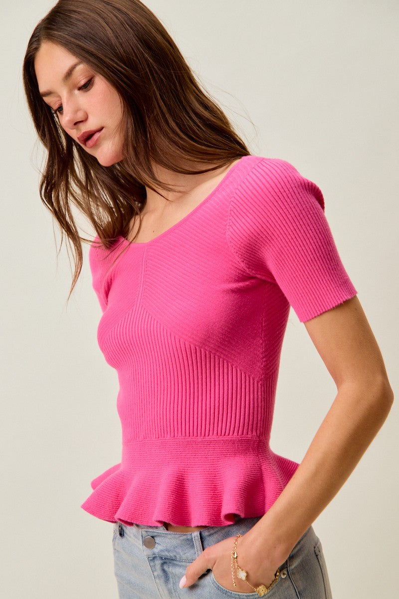Hot pink ribbed knit peplum sweater top, draped peplum detail in view