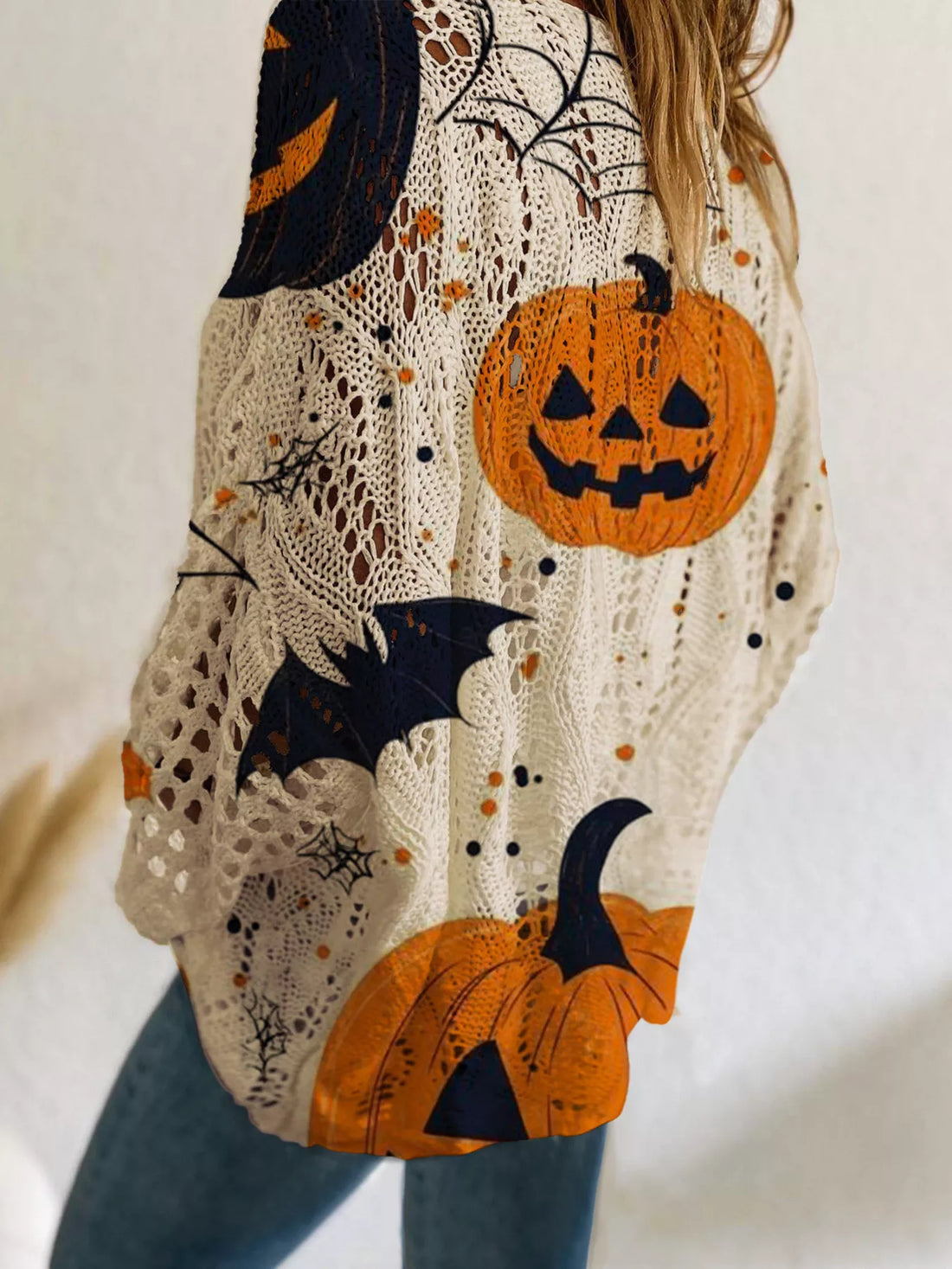 Plus size loose knit cover-up with cream base and orange pumpkin, bat, and moon print.