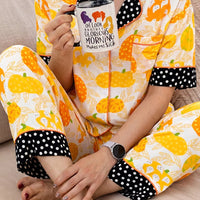 Short-sleeve pumpkin print pajama set with polka-dot trim; close-up of pocket and buttons