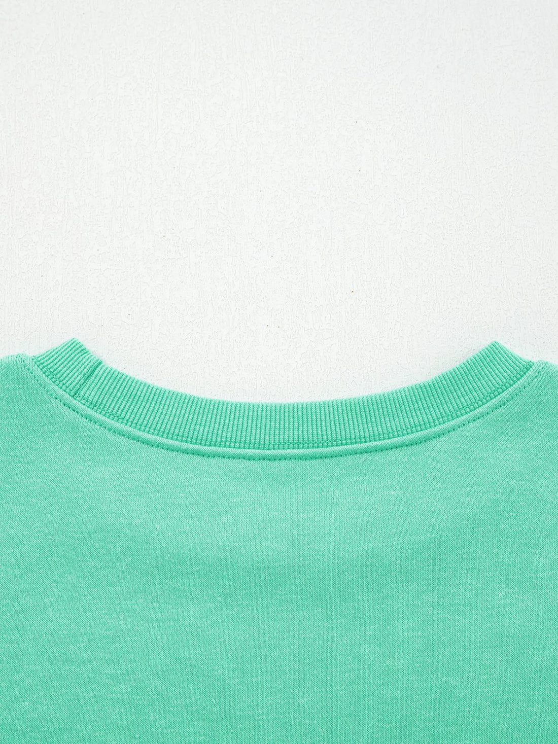 Turquoise crewneck sweatshirt ribbed neckline close-up