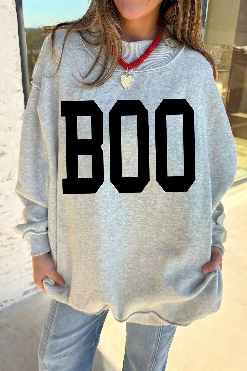 Light gray reversible mock-neck sweatshirt with large black “BOO” front graphic