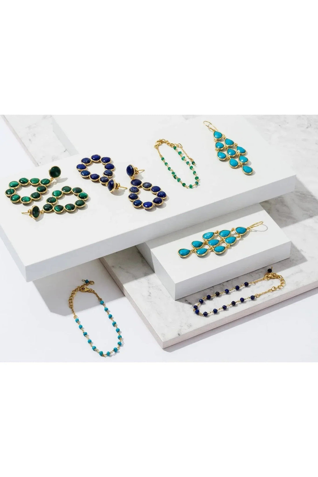 Turquoise drop earrings on a gold-tone jewelry display tray