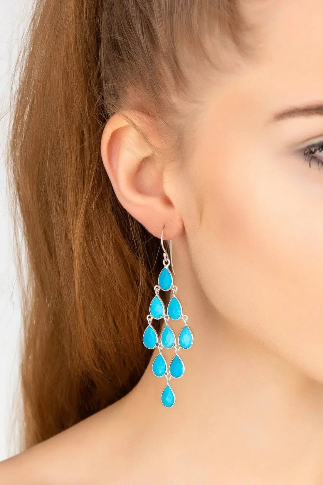 Turquoise teardrop chandelier earrings on silver hooks, side view