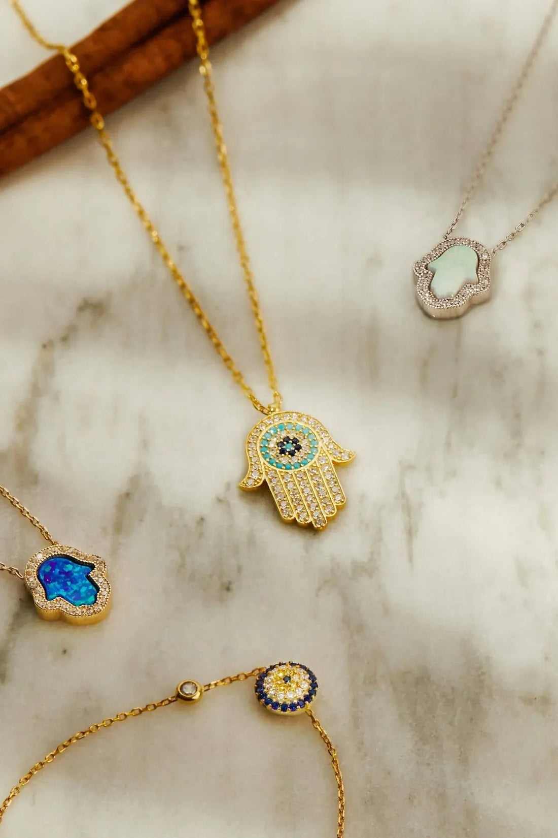 Gold evil eye charm bracelet with round blue eye bead