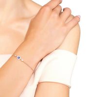 Silver evil eye enamel bracelet with dark blue eye charm on wrist