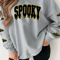 Gray Halloween sweatshirt with sequin 'SPOOKY' front graphic and bat sleeve accents