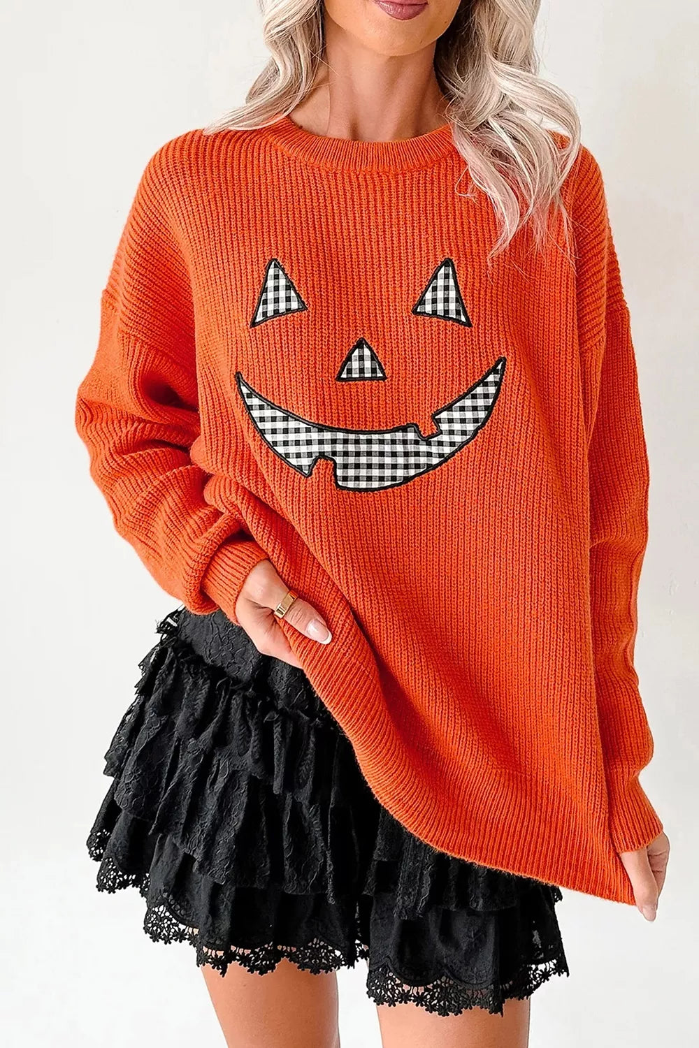 Orange knit long-sleeve sweater with round neck and jack-o-lantern graphic