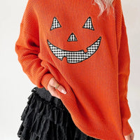 Orange knit long-sleeve sweater with round neck and jack-o-lantern graphic