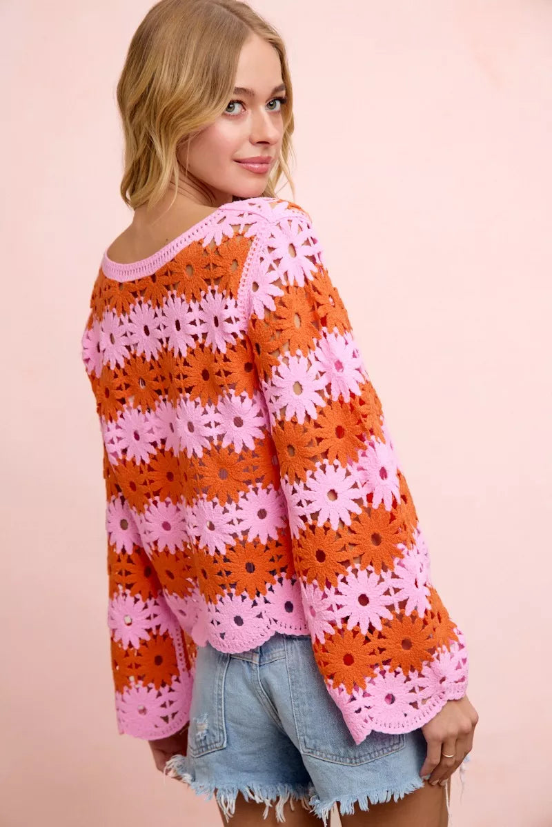 Floral crochet knit top in orange and pink with long sleeves and ribbed scoop neck.