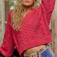Fuchsia cable-knit cropped V-neck sweater, voluminous sleeves with textured cable pattern