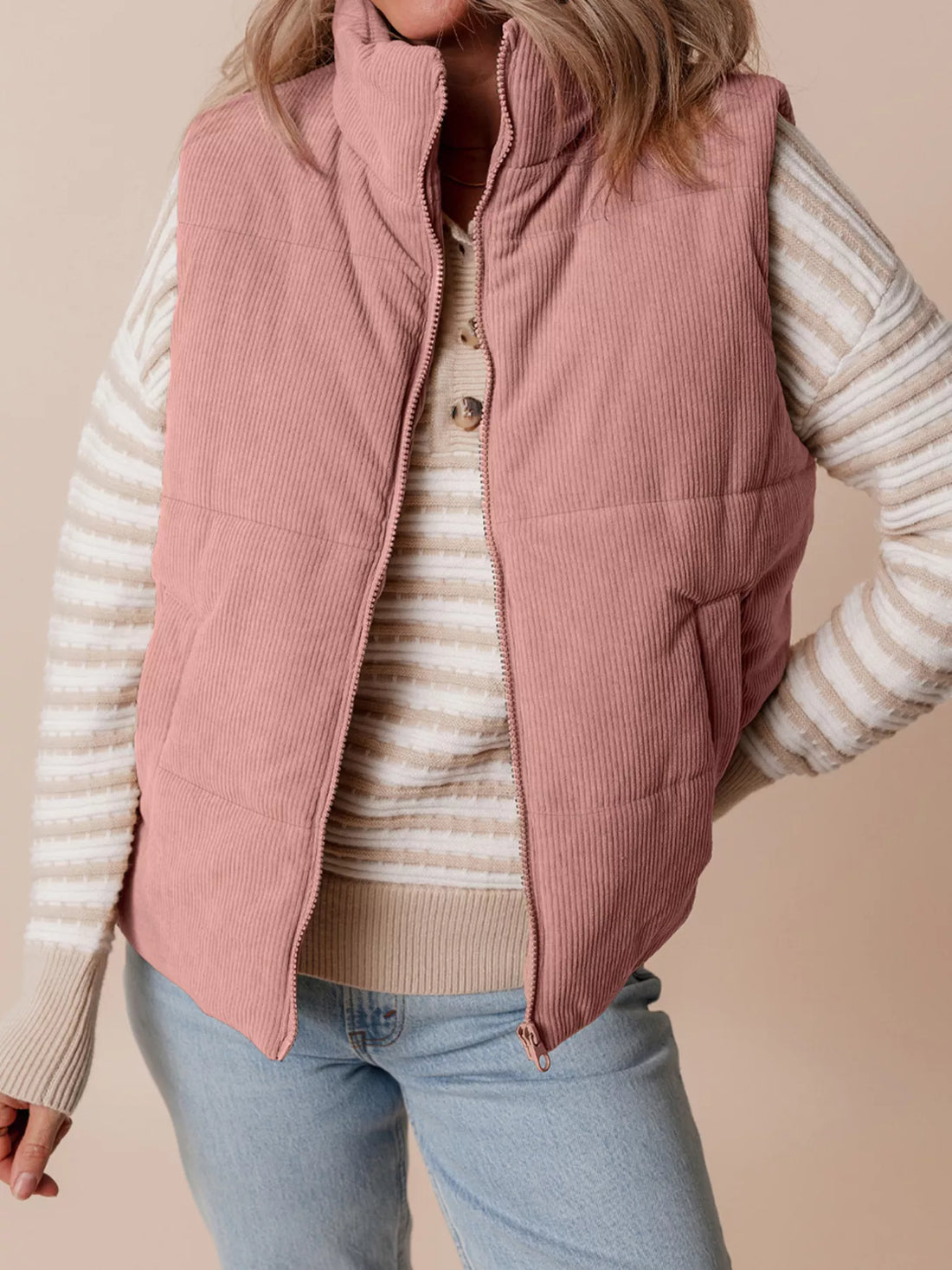 Dusty pink corduroy stand-neck zipped puffer vest with pockets and full zipper.