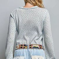 Back view of light blue speckled knit crew neck long-sleeve top
