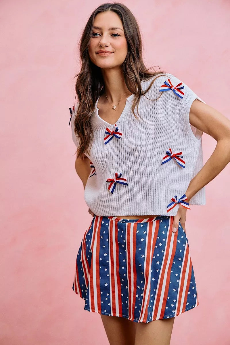 Off-white dolman sweater top featuring multiple ribbon bows over a knit texture