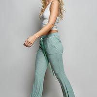 Pale sage knit drawstring flare pants with long drape and side seam pockets