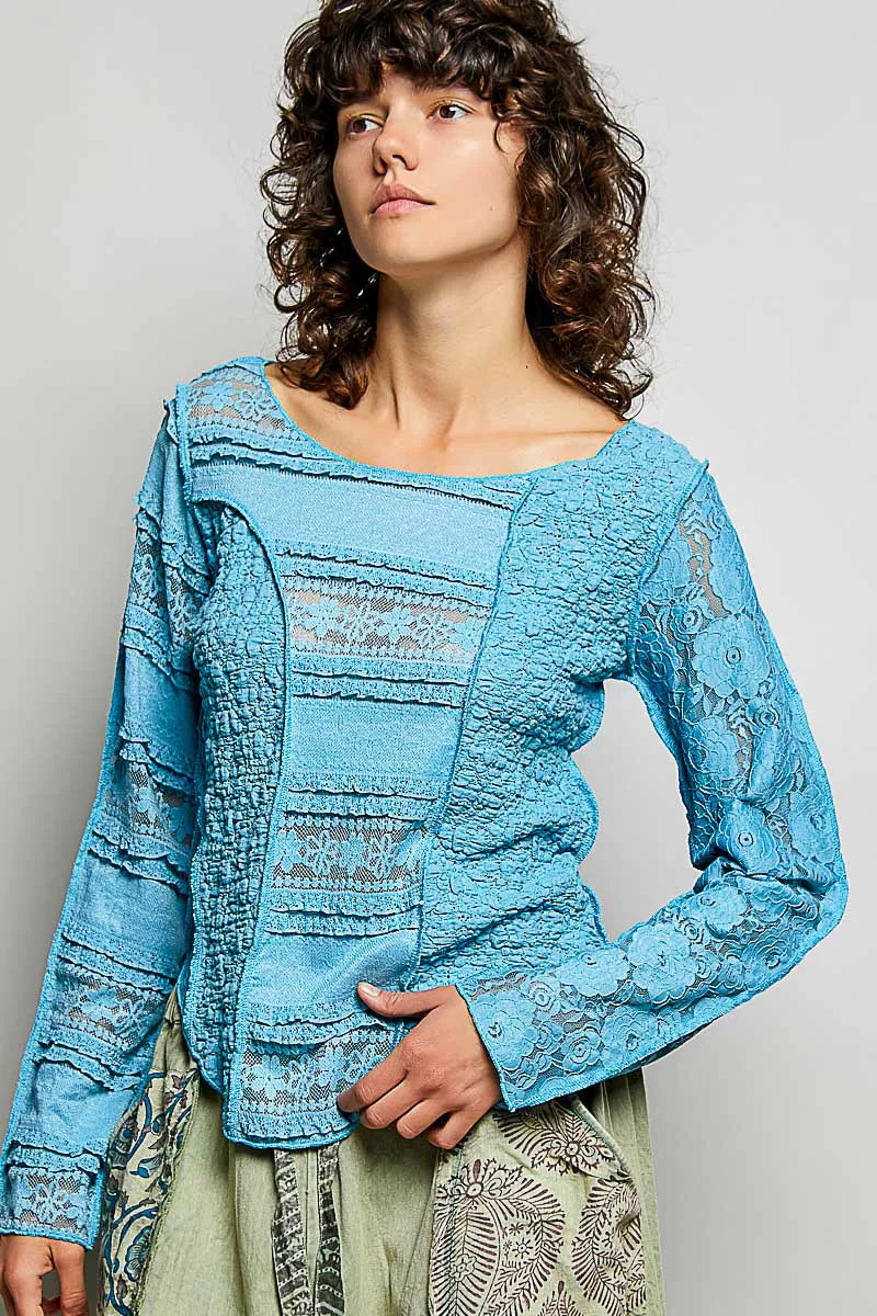 Teal blue lace long-sleeve top with exposed seams and round neckline, close-up