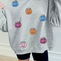 Gray long-sleeve sweatshirt with scattered jack-o'-lantern face graphic
