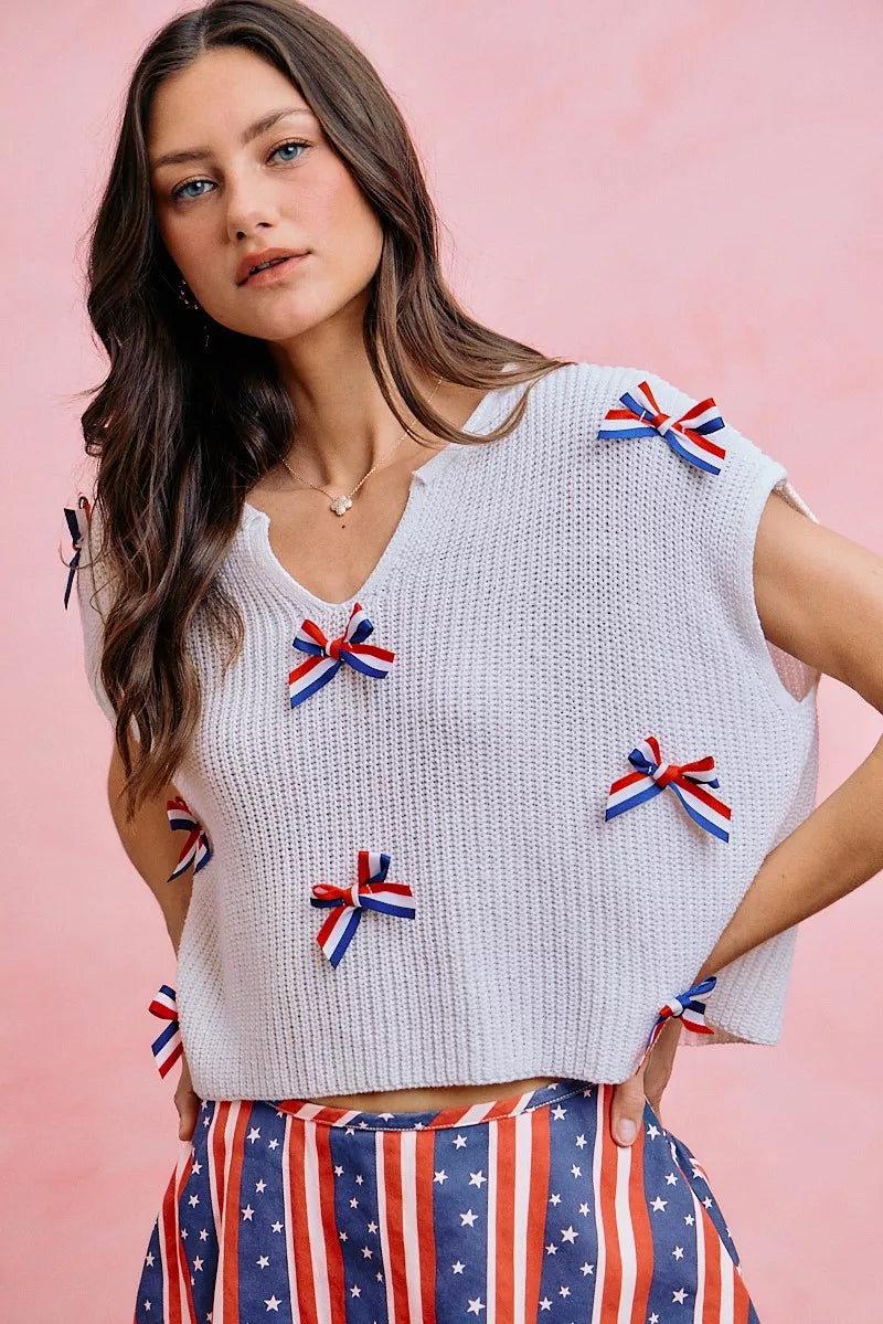 Off-white dolman sweater top with ribbon bows and a simple crew neckline