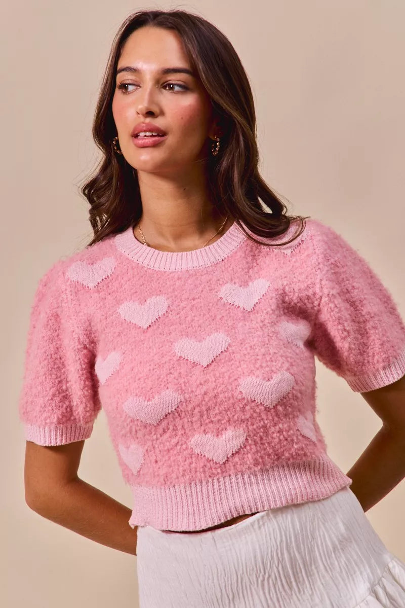 Pink cropped heart-pattern sweater with crew neck and short sleeves, ribbed cuffs