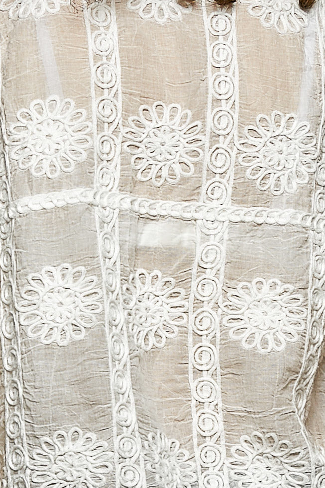 Off-white button-down V-neck sweater vest with floral embroidery and braided trim