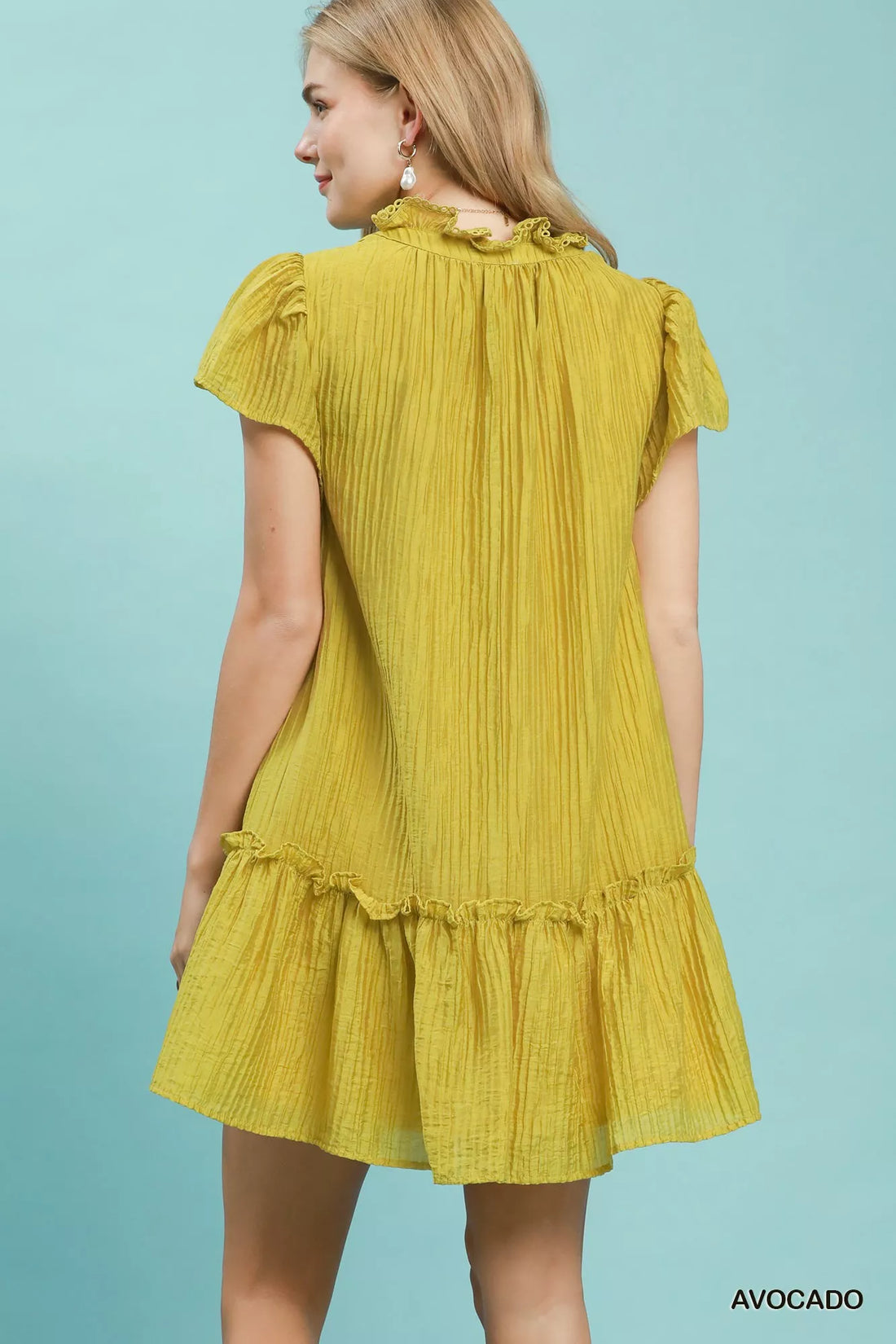 Back view of Avocado textured mini dress with ruffled cap sleeves and tiered hem
