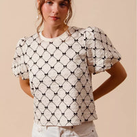 Ivory woven bubble sleeve top with black bow texture pattern, round neckline