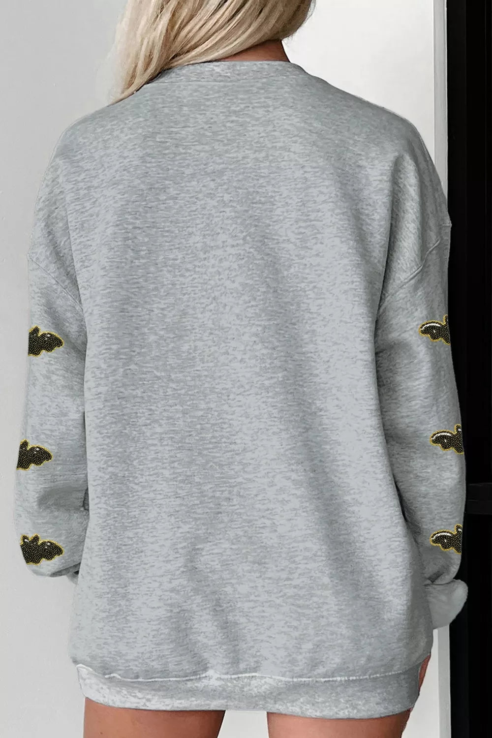 Gray Halloween sweatshirt back view with bat-pattern sleeves