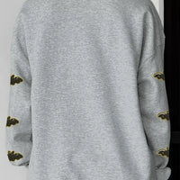 Gray Halloween sweatshirt back view with bat-pattern sleeves