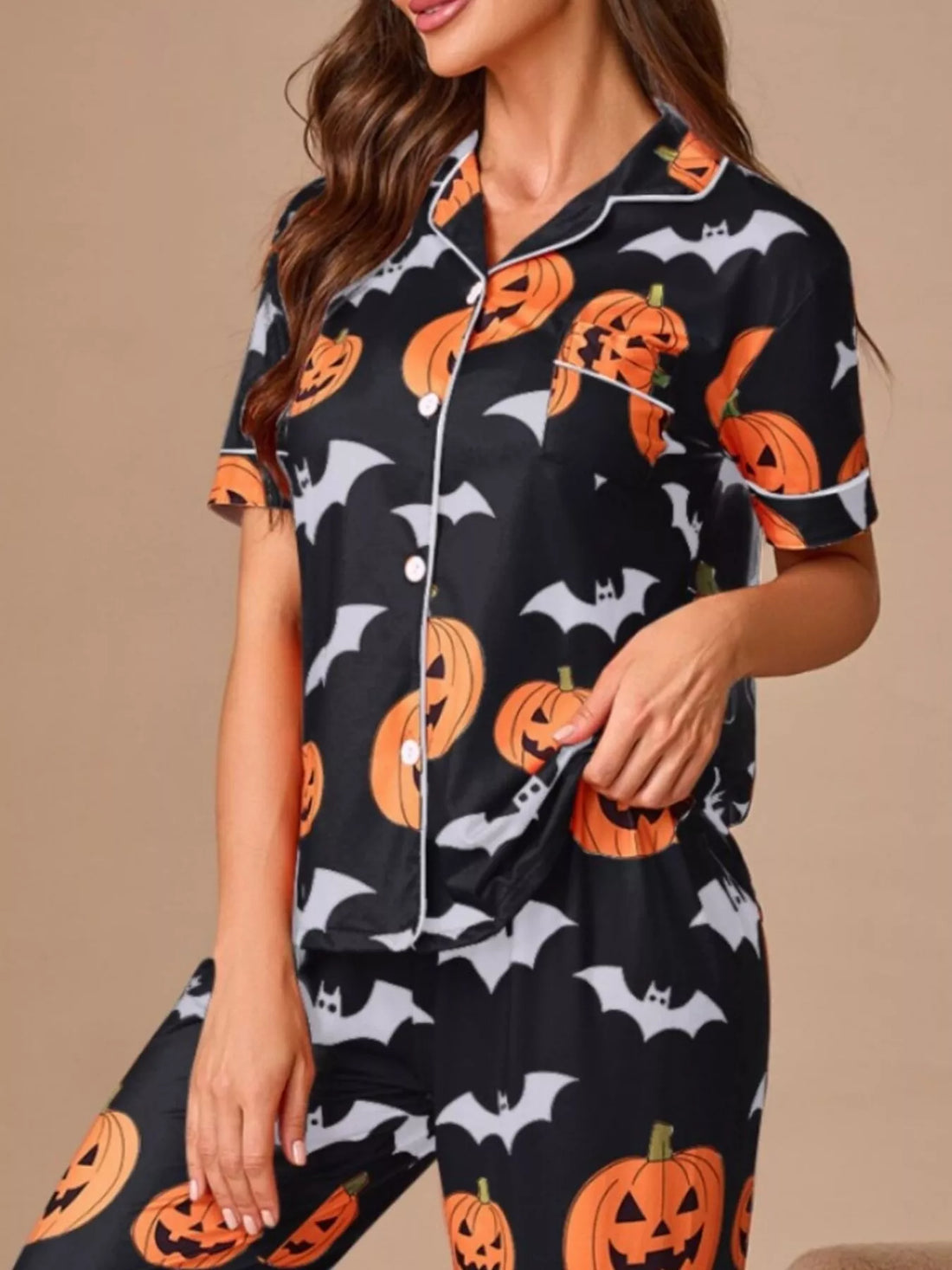Black button-front pajama set with orange pumpkin and bat print, short-sleeve top and pants