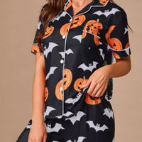 Black button-front pajama set with orange pumpkin and bat print, short-sleeve top and pants