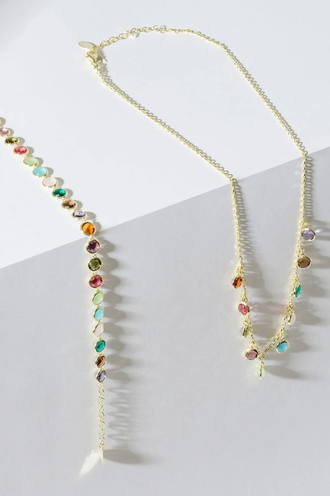 Gold multi-colored gemstone necklace angled view, round beads with colorful drops