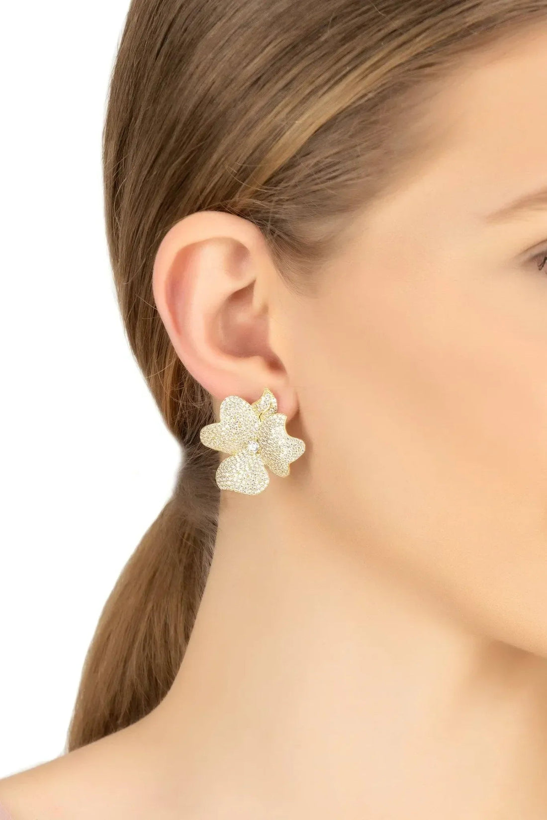 Gold flower stud earrings on model&