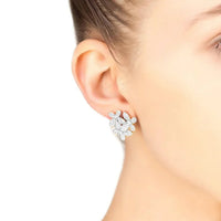 Large silver flower stud earrings worn on ear