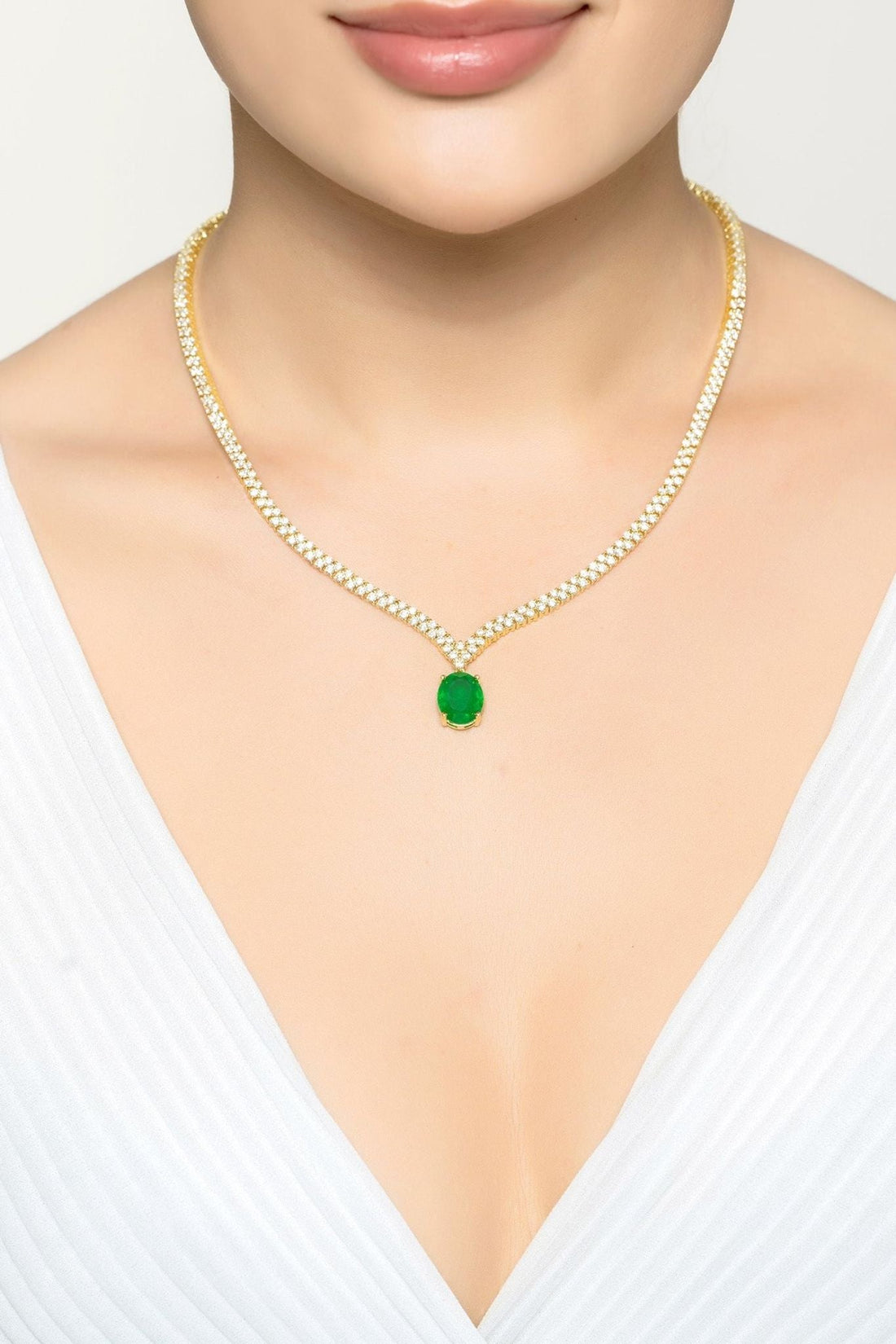 Gold tennis necklace with small green oval pendant, clear pave chain