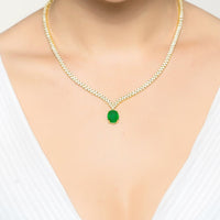 Gold tennis necklace with small green oval pendant, clear pave chain