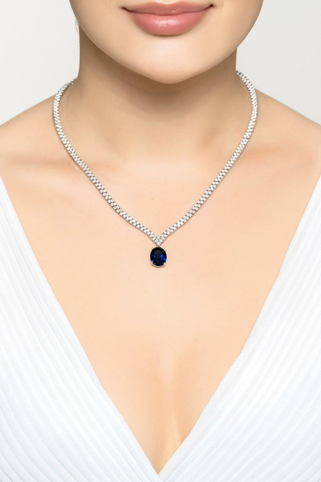 Silver tennis necklace with oval sapphire pendant