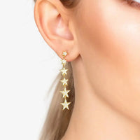 Gold star drop earrings with five star charms, seen from side