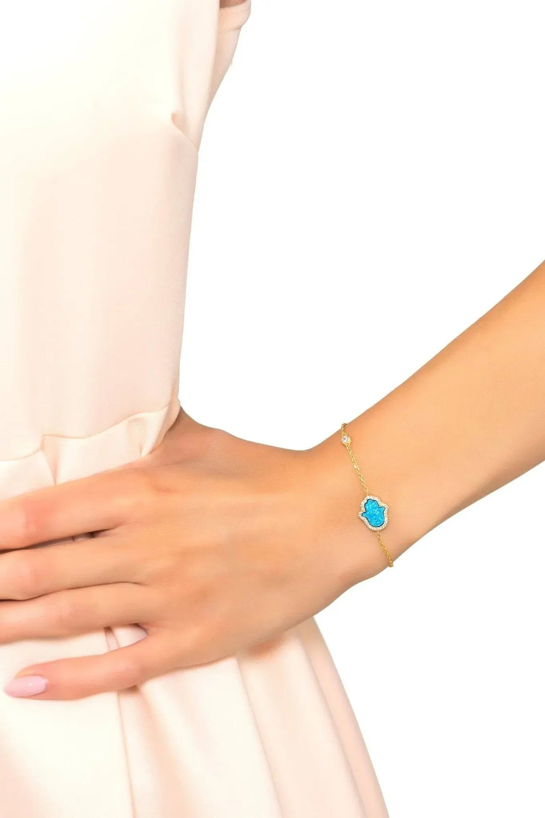 Gold chain bracelet with blue opalite Hamsa charm on wrist