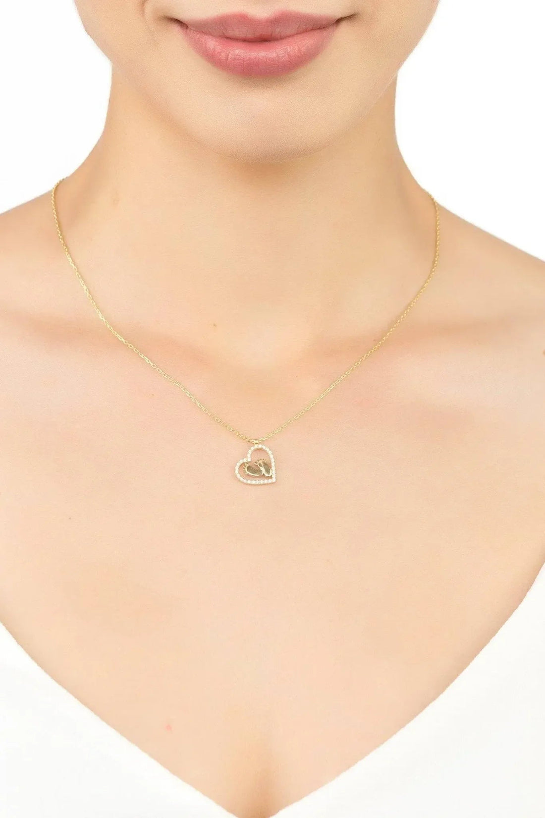 Gold heart pendant necklace with small heart charm at the center