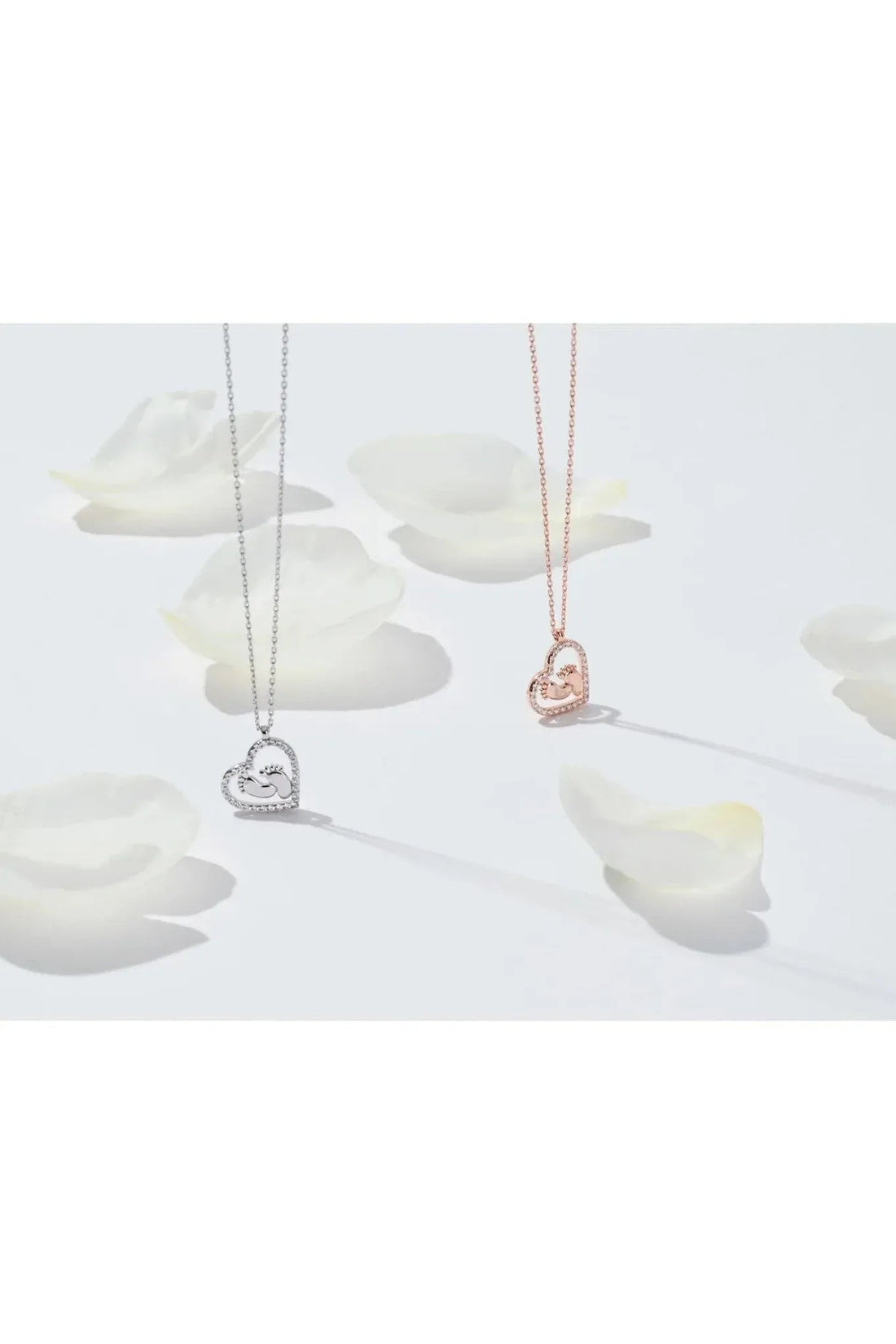 Silver and rose-gold heart mum pendant necklaces with small handprint charms.