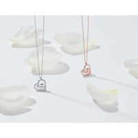 Silver and rose-gold heart mum pendant necklaces with small handprint charms.