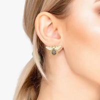 Gold honey bee stud earrings worn on ear, crystal wings and black enamel body