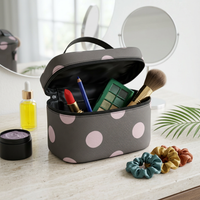 Brown polka dot makeup bag travel case open with makeup brushes and lip products inside