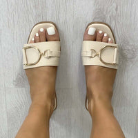 Beige open-toe slide sandals with wide strap and gold tone ring detail