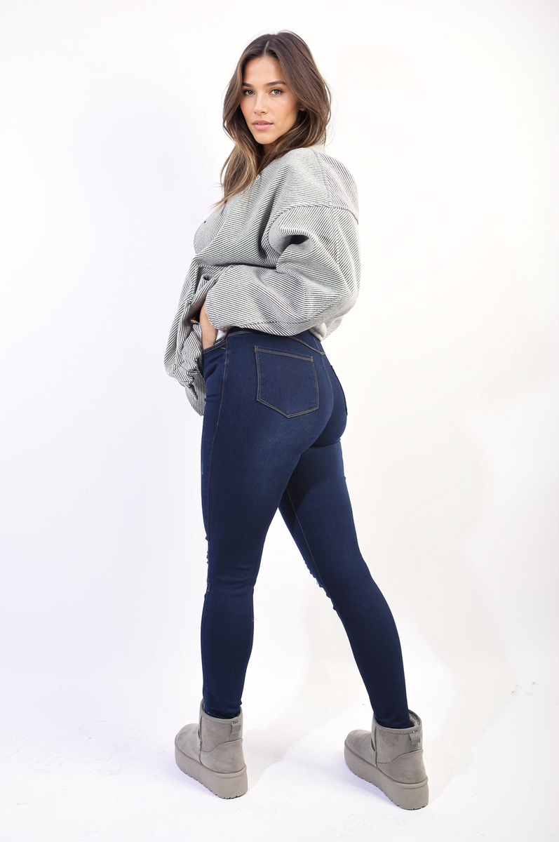 Navy blue high-waisted skinny jeggings with ripped knees and subtle side whiskering