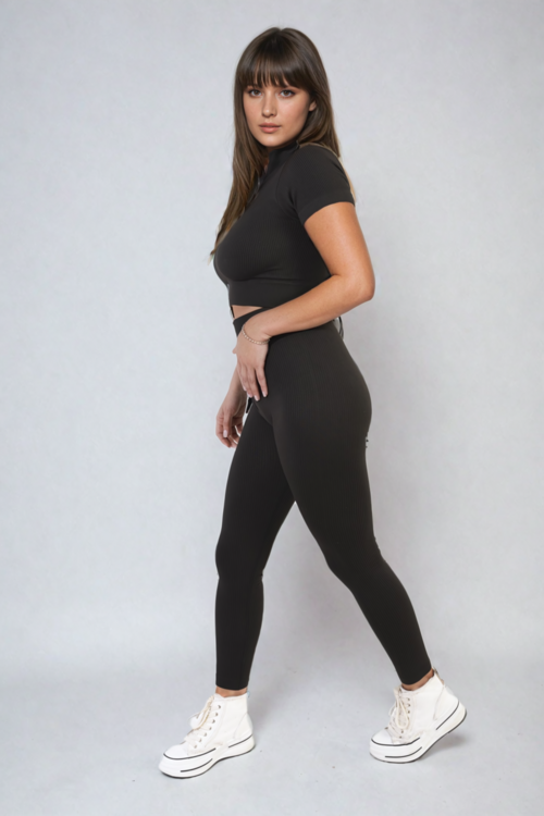 Black ribbed half-zip crop top and high-waist leggings set, fitted two-piece.
