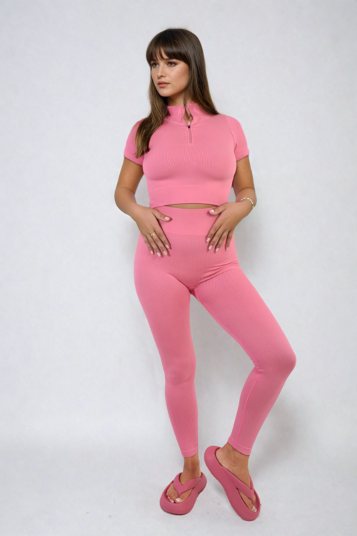 Pink half-zip crop top and high-waist leggings set, ribbed stretch knit, fitted two-piece.